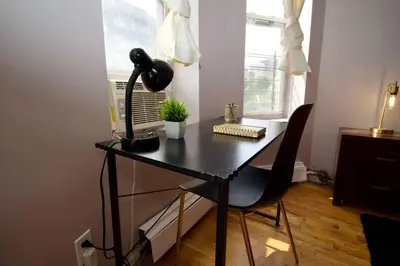 a desk with a lamp and a chair in a room at Tuk Ahoy - Sunset Suite 2B with Shared Spaces in Brooklyn