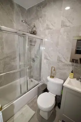 a bathroom with a shower and a toilet and a sink at Tuk Ahoy - Sunset Suite 2B with Shared Spaces in Brooklyn