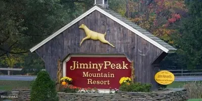a sign for a mountain resort with a dog on top at 1st Floor Mountain View Suite Ski On Off At Jiminy- Fully Redone Decor in Hancock