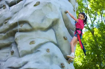 a little girl climbing on a rock wall at 1st Floor Mountain View Suite Ski On Off At Jiminy- Fully Redone Decor in Hancock