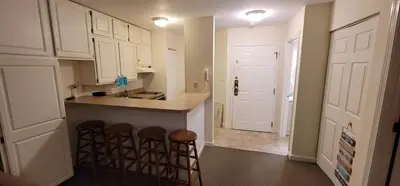 a kitchen with a counter and some stools in it at 1st Floor Mountain View Suite Ski On Off At Jiminy- Fully Redone Decor in Hancock