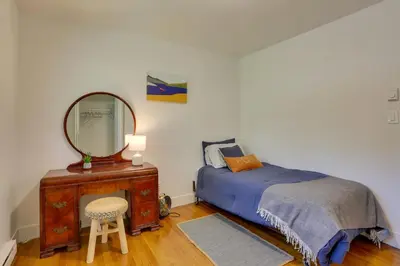 a bedroom with a bed and a mirror and a chair at Kiamesha Lake Home with Deck 4 Mi to Resorts World! in Monticello