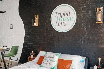a bedroom with a bed and a sign on a brick wall at Tripoli Artisan Lofts - Designer Bushwick Lofts with Rooftop Terrace in Brooklyn