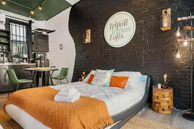 a bedroom with a bed and a brick wall at Tripoli Artisan Lofts - Designer Bushwick Lofts with Rooftop Terrace in Brooklyn