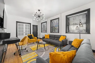 a living room with a couch and a table at Tripoli Artisan Lofts - Designer Bushwick Lofts with Rooftop Terrace in Brooklyn