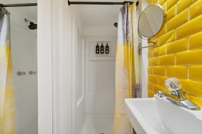 a bathroom with a sink and a mirror and a shower at Tripoli Artisan Lofts - Designer Bushwick Lofts with Rooftop Terrace in Brooklyn