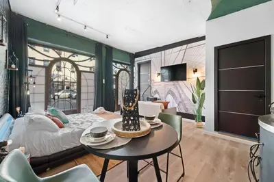 a room with a bed and a table and chairs at Tripoli Artisan Lofts - Designer Bushwick Lofts with Rooftop Terrace in Brooklyn