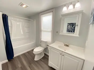 a white bathroom with a toilet and a sink at 3rd Base Apt 1 All Star Baseball Rentals in Oneonta