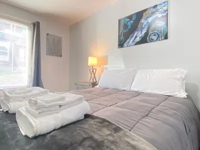 a bedroom with a large bed with white sheets at 3rd Base Apt 1 All Star Baseball Rentals in Oneonta