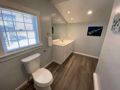 a white bathroom with a toilet and a sink at 3rd Base Apt 2 All Star Baseball Rentals in Oneonta
