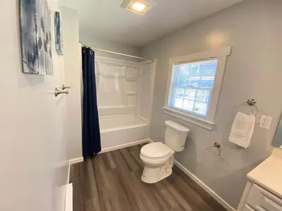 a white bathroom with a toilet and a shower at 3rd Base Apt 2 All Star Baseball Rentals in Oneonta