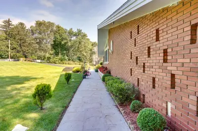a brick building with a sidewalk next to a yard at Cozy Albany Vacation Rental about 5 Mi to Downtown! in Albany