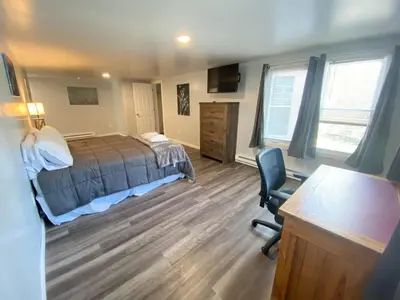 a bedroom with a bed and a desk and a chair at Double Play Apt 1 All Star Baseball Rentals in Oneonta