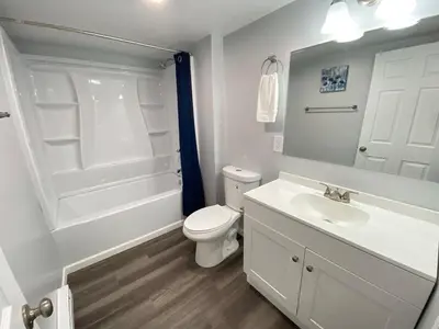 a white bathroom with a toilet and a sink at Double Play Apt 1 All Star Baseball Rentals in Oneonta