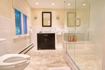 a bathroom with a toilet and a sink and a shower at Fun on the Lake in East Hampton