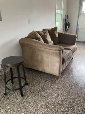 a brown couch and a stool in a living room at Fun on the Lake in East Hampton