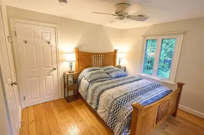a bedroom with a bed and a ceiling fan at Fun on the Lake in East Hampton