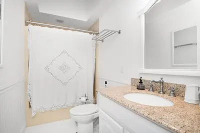 a white bathroom with a toilet and a sink at Lakeview Expanse in Bethlehem