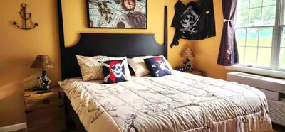 a bedroom with a bed with pillows on it at Must See Pirate Suite Ski On Off Jiminy - Mtn View Fully Redone Decor in Hancock