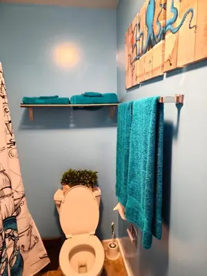 a bathroom with a toilet and two blue towels at Must See Pirate Suite Ski On Off Jiminy - Mtn View Fully Redone Decor in Hancock