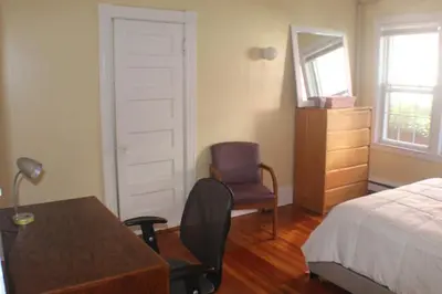 a bedroom with a bed and a desk and a chair at West End Haven in Hartford