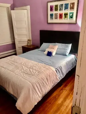 a bedroom with a large bed with purple walls at West End Haven in Hartford