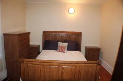 a bedroom with a wooden bed with a pillow on it at West End Haven in Hartford