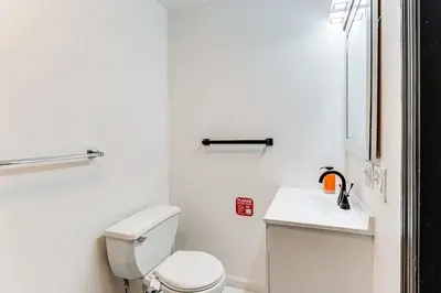 a white bathroom with a toilet and a sink at 3br private Apartment in Jersey City