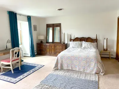 a bedroom with a large bed and a chair at Daydream Mountain Art Chateau in Catskill