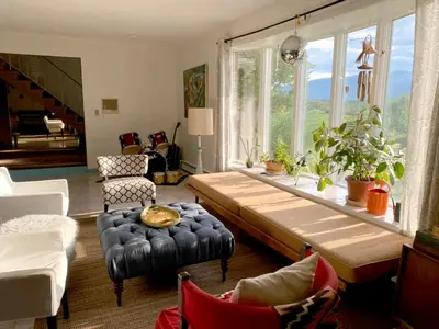 a living room with a table and a large window at Daydream Mountain Art Chateau in Catskill