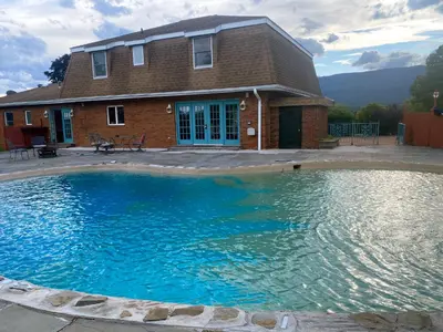a large swimming pool in front of a house at Daydream Mountain Art Chateau in Catskill