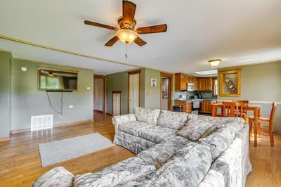 a living room with a couch and a ceiling fan at Buskirk Vacation Rental with Deck and Putting Green! in Buskirk