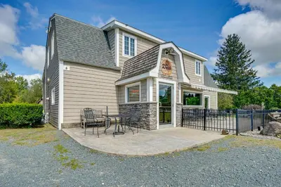 a house with a patio with a table and chairs at Buskirk Vacation Rental with Deck and Putting Green! in Buskirk