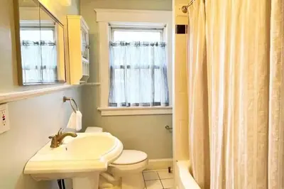 a bathroom with a sink and a toilet and a window at Modern Home off I-95 Perfect for Families & Business Stay with Ample Parking in Stamford