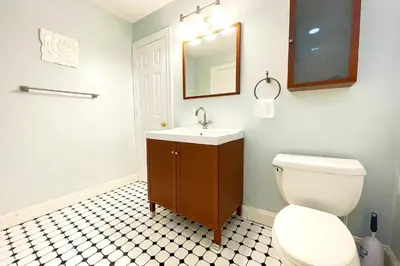 a bathroom with a toilet and a sink and a mirror at Modern Home off I-95 Perfect for Families & Business Stay with Ample Parking in Stamford