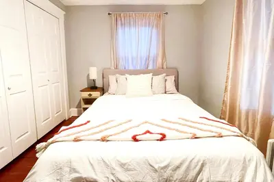 a bedroom with a white bed with a window at Modern Home off I-95 Perfect for Families & Business Stay with Ample Parking in Stamford