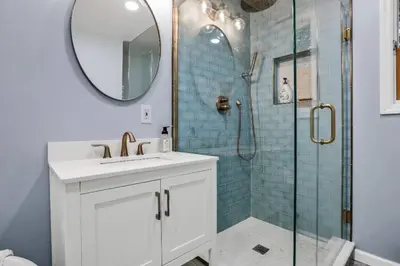 a bathroom with a sink and a shower with a mirror at 3 Bedroom Hilltop Escape with 5 Private Acres and Hot Tub in Marlboro
