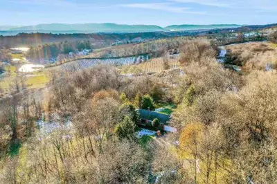 an aerial view of a field with trees and a train at 3 Bedroom Hilltop Escape with 5 Private Acres and Hot Tub in Marlboro