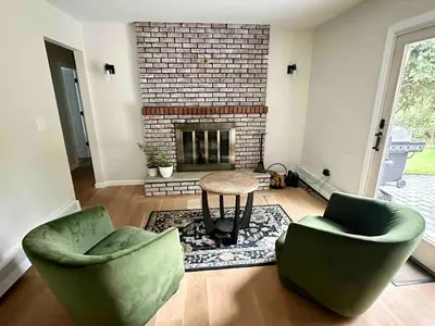 a living room with two chairs and a table and a fireplace at 3 Bedroom Hilltop Escape with 5 Private Acres and Hot Tub in Marlboro