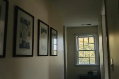 a hallway with pictures on the wall and a window at Urban Downtown Stamford Home 45 min to NYC with Garage And Yard in Stamford