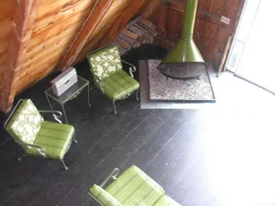 a room with two green chairs and a fireplace at Cabin A-frame - Beautiful Cabin in Laurel Island in East Hampton