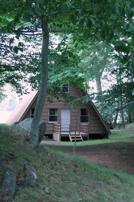 a small house with a porch and a tree at Cabin A-frame - Beautiful Cabin in Laurel Island in East Hampton