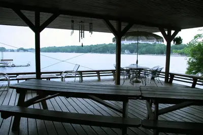a wooden deck with a table and chairs and an umbrella at Cabin A-frame - Beautiful Cabin in Laurel Island in East Hampton
