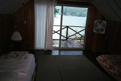 a bedroom with a window with a view of the water at Captains Cabin - Cozy Cabin in Laurel Island in East Hampton