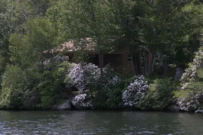 a house on the shore of a river with flowers at Cabin Chalet - Breathtaking Cabin in Laurel Island in East Hampton