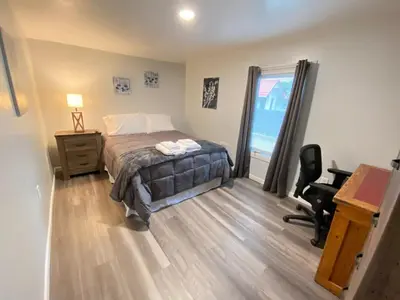 a bedroom with a bed and a desk and a window at Double Play Apt 2 All Star Baseball Rentals in Oneonta