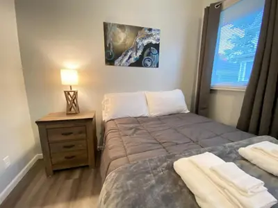 a bedroom with a bed and a night stand and a window at Double Play Apt 2 All Star Baseball Rentals in Oneonta