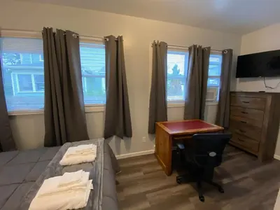 a bedroom with a desk and a bed and a dresser at Double Play Apt 2 All Star Baseball Rentals in Oneonta