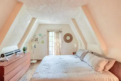 a bedroom with a large bed in a attic at A-Frame Cabin with Furnished Deck in Becket! in Becket