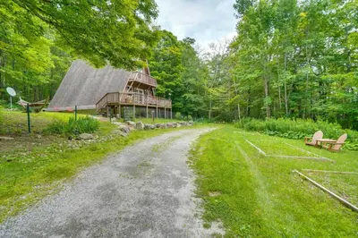 a dirt road leading to a house in the woods at A-Frame Cabin with Furnished Deck in Becket! in Becket